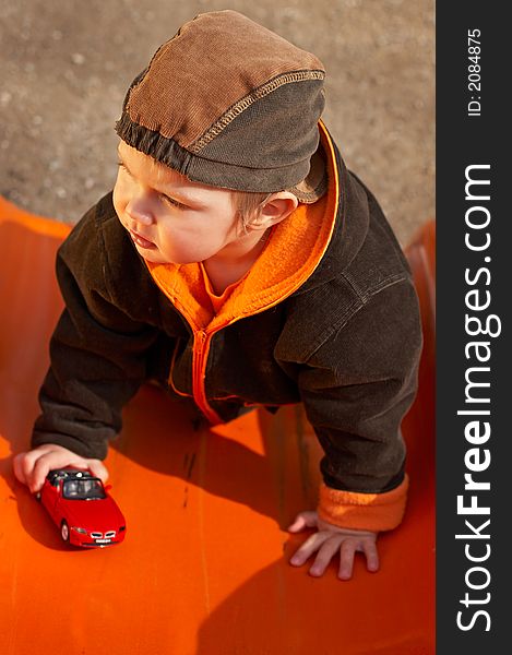 Lovely Baby Boy with beautiful blue eyes playing with toy car in the park