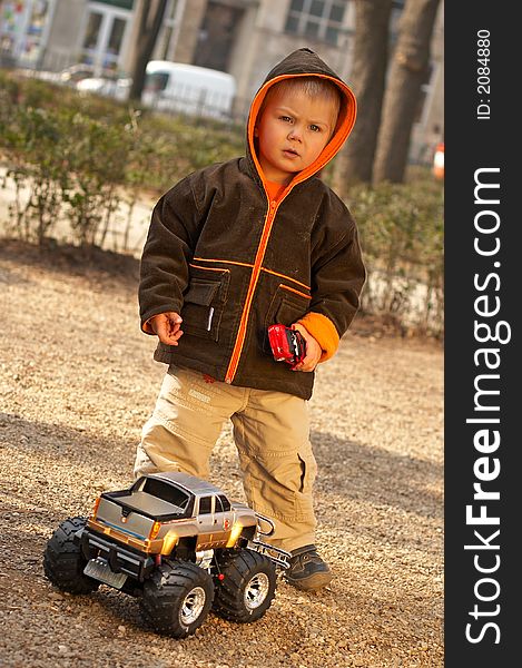 Lovely Baby Boy playing with toy monster truck shot in studio