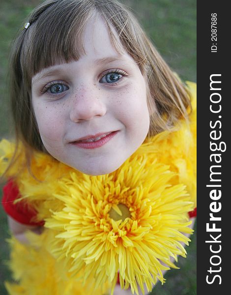 Young girl holding a yellow flower. Young girl holding a yellow flower