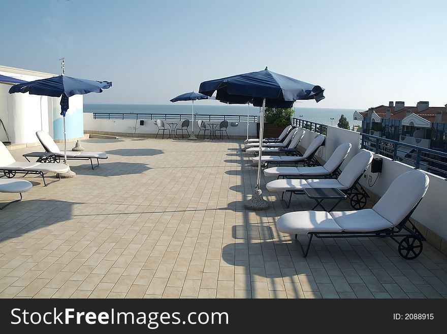 Beach scene with blue umbrellas, chairs and relax equipment. Beach scene with blue umbrellas, chairs and relax equipment