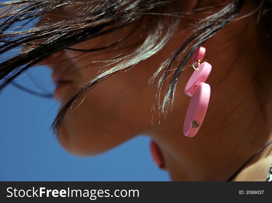 Female accessory in girl's ear & her hair. Female accessory in girl's ear & her hair