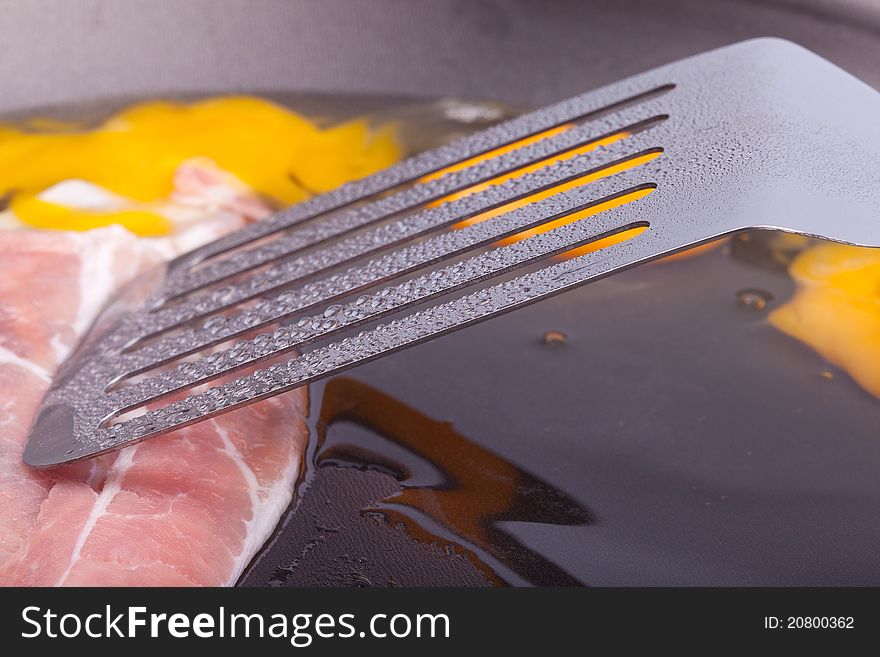 Studio-shot of preparing breakfast in a pan with ham and fried eggs.