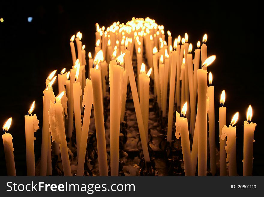 Burning candles in a Milan cathedral, Italy. The photo is executed in the spring of 2011.