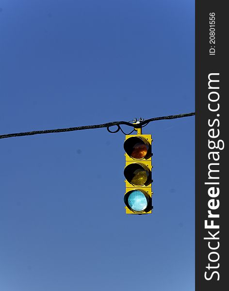 A traffic light against a clear and bright blue sky.