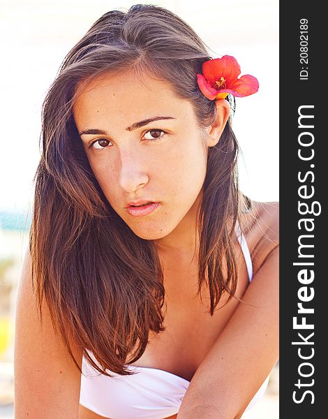 Seductive woman at the beach with a flower in her hair. Seductive woman at the beach with a flower in her hair