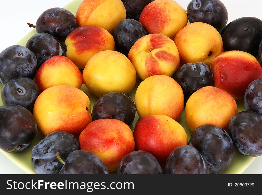 Still life with natural ripe plums and peaches on a white background