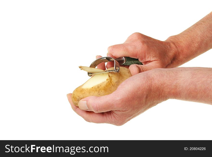 Pair of male hands peeling a potato with a speed peeler against white. Pair of male hands peeling a potato with a speed peeler against white