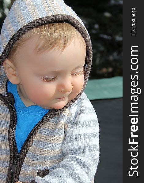 Baby boy playing outside in the garden wearing jersey. Baby boy playing outside in the garden wearing jersey