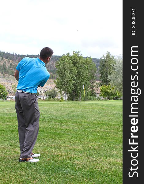 Young golfer hitting a fairway shot with an iron