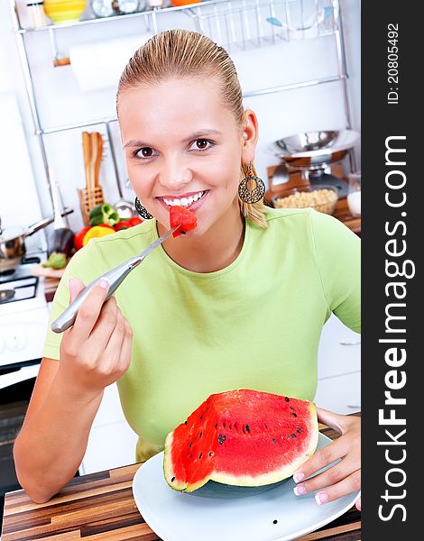 Lovely woman eating watermelon in the kitchen-diet concept. Lovely woman eating watermelon in the kitchen-diet concept