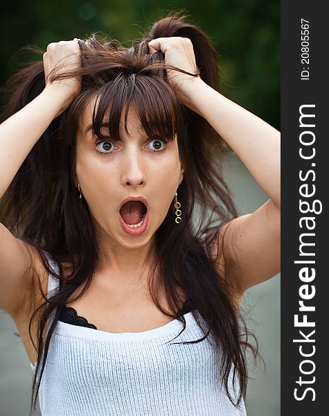 Surprised young woman tearing her hair. Surprised young woman tearing her hair