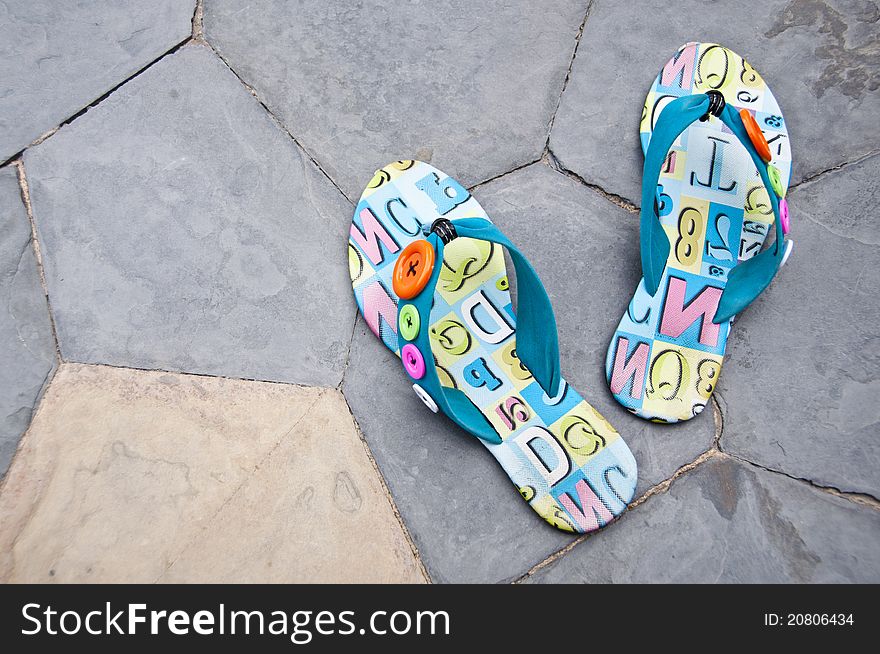 Colorful sandals on the floor near swimming pool. Colorful sandals on the floor near swimming pool.