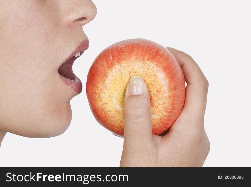 Young woman eating fruit in a white background. Young woman eating fruit in a white background