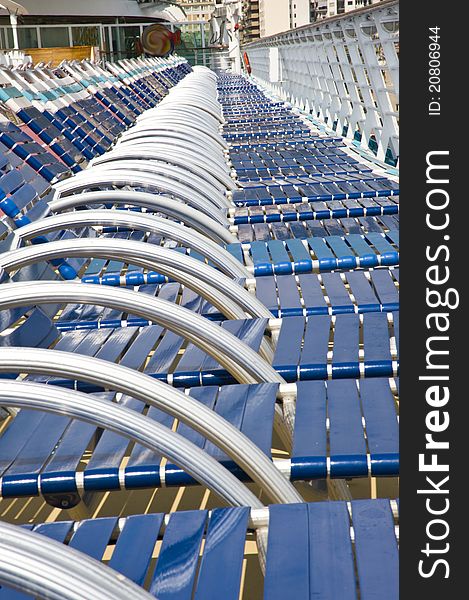 Many beach chairs in a long row on a cruise ship