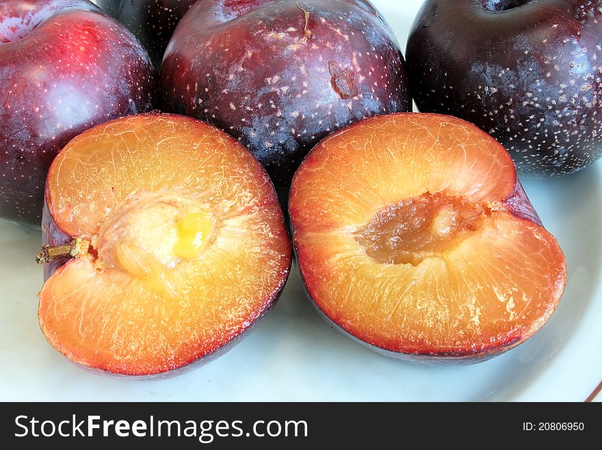Ripe red plums on plate