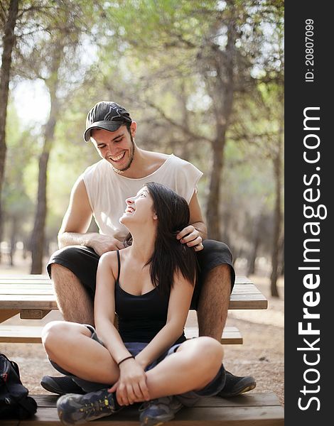 Young happy couple smiling each other in the forest. Young happy couple smiling each other in the forest.