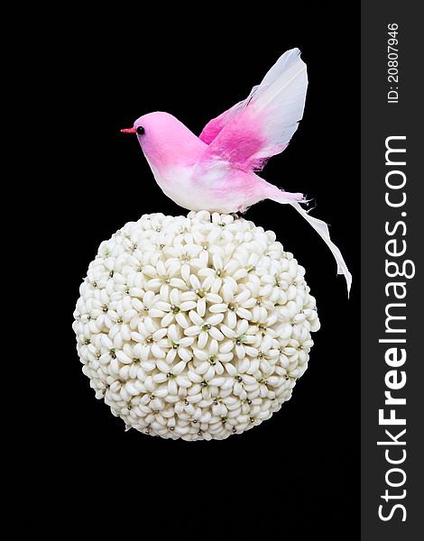 Flower ball and paper bird isolated on black background