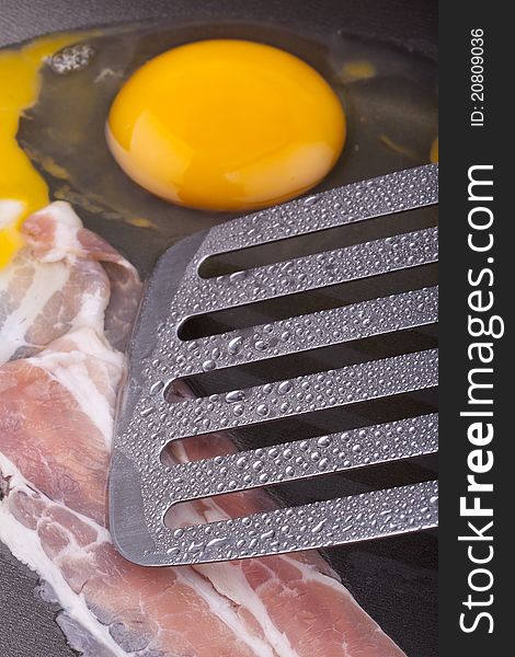 Studio-shot of preparing breakfast in a frying pan with ham and fried eggs