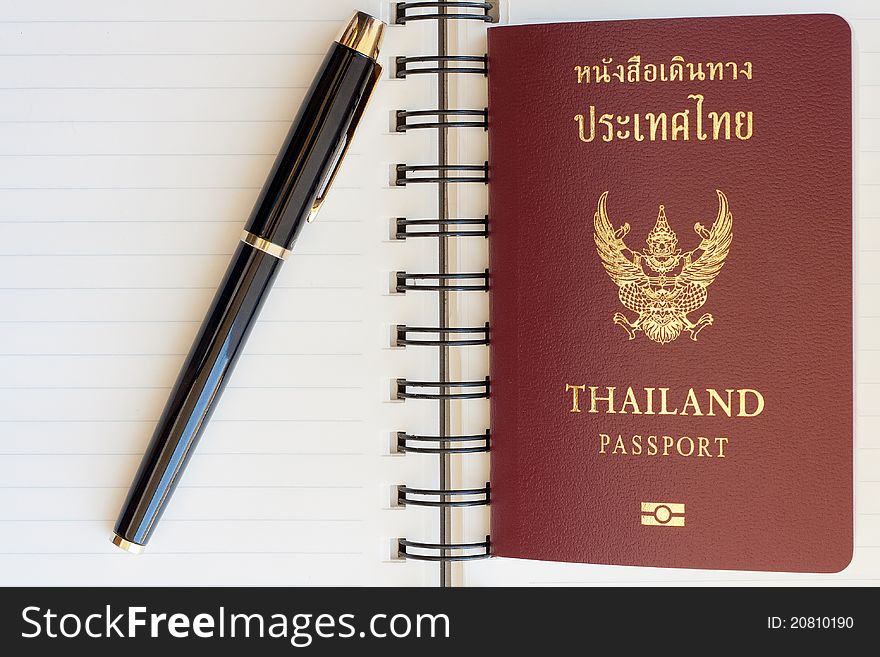 Thailand passport and pen on blank page in a spiral bound notebook