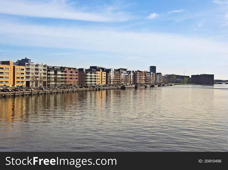 Modern architecture in Amsterdam. Island of Borneo. Modern housing is reflected in the water against the blue sky.