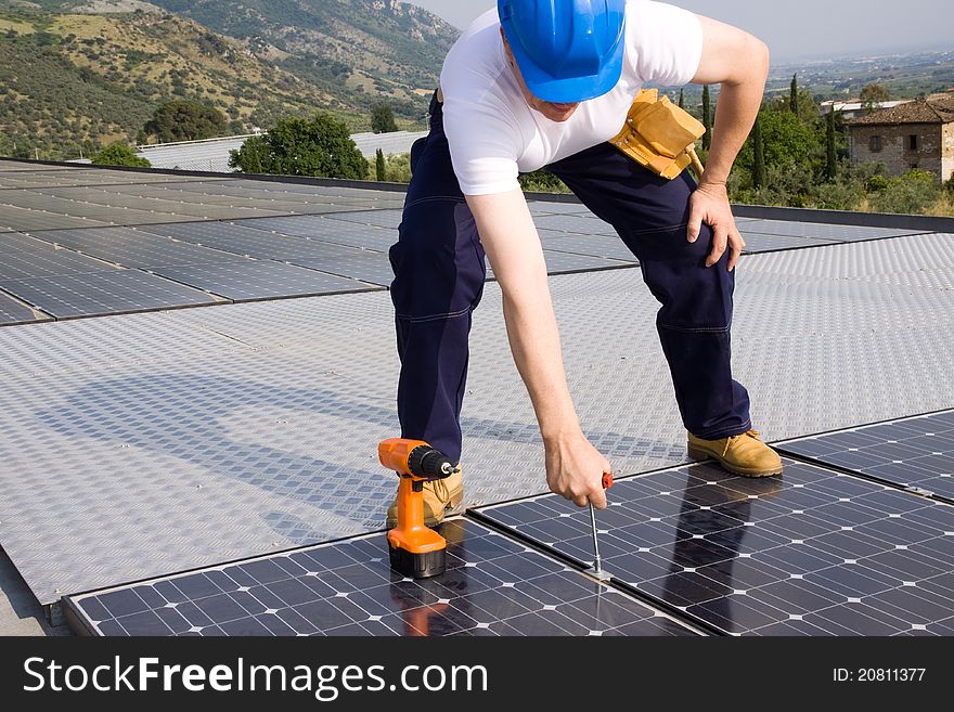 A man working in a photovoltaic plant for producing energy. A man working in a photovoltaic plant for producing energy