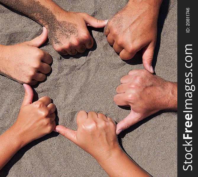 Image of hands on sand - circle form