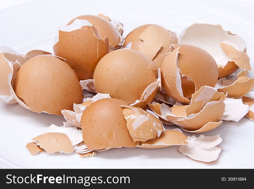 Eggs shell scattered on a white background