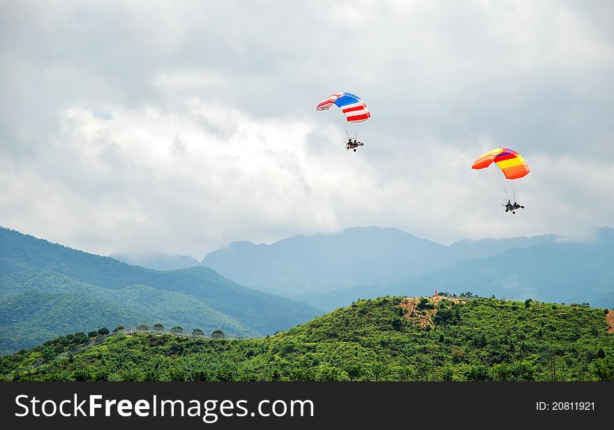 Two powered parachutes over the mountains.