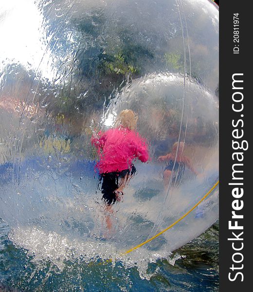Two children playing in big balloons so-called waterbubbles