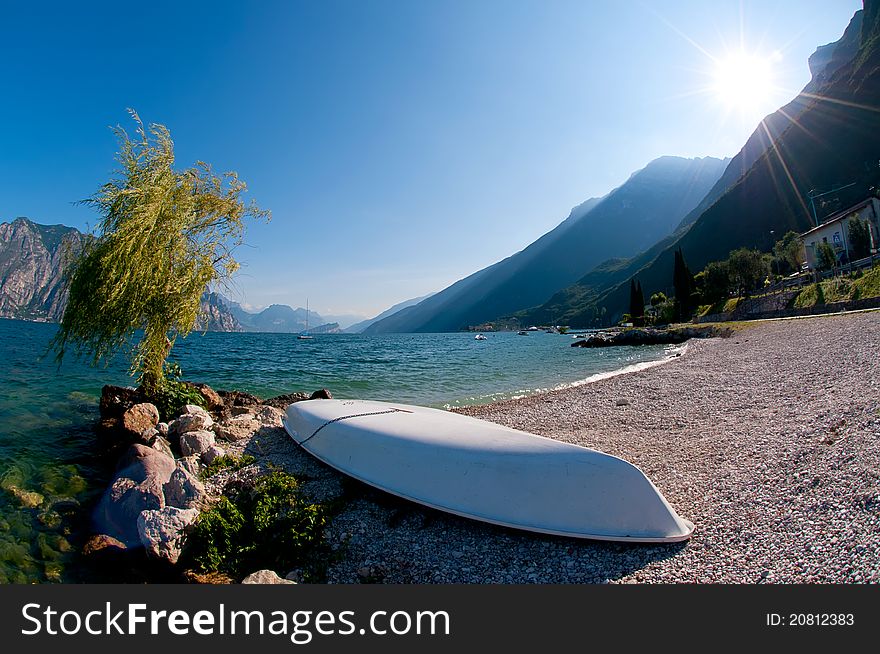 Wide angle view of a boat by the an italian mountain lake. Wide angle view of a boat by the an italian mountain lake