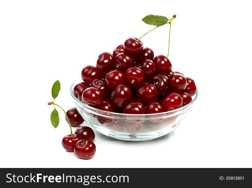 A glass bowl full with sweet cherries. A glass bowl full with sweet cherries