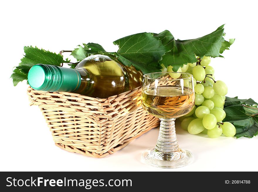 A bottle of white wine and fresh grapes on a white background