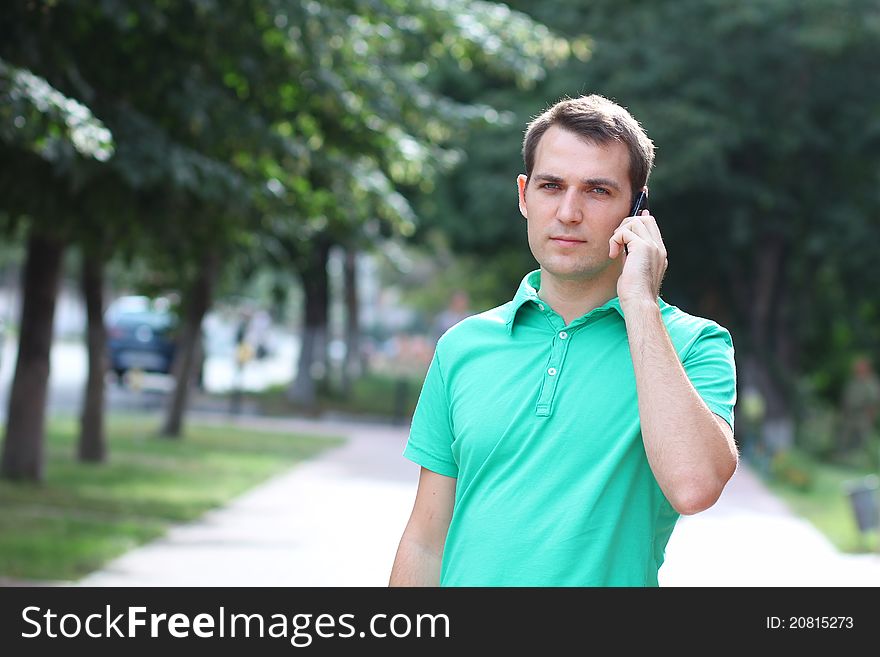 Young man calling by phone in the street