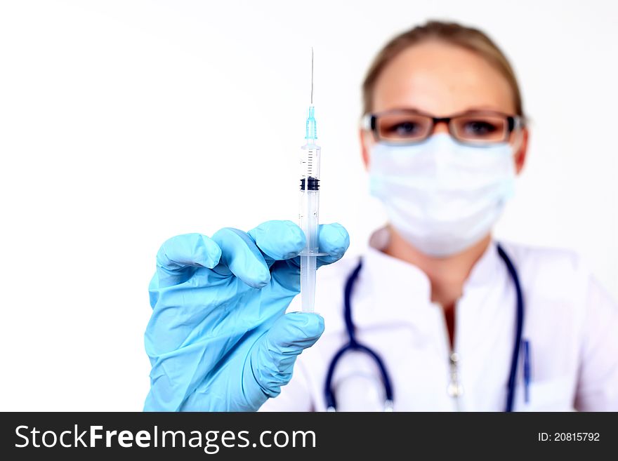 Young female doctor in white uniform wearing mask and gloves with syringe. Young female doctor in white uniform wearing mask and gloves with syringe