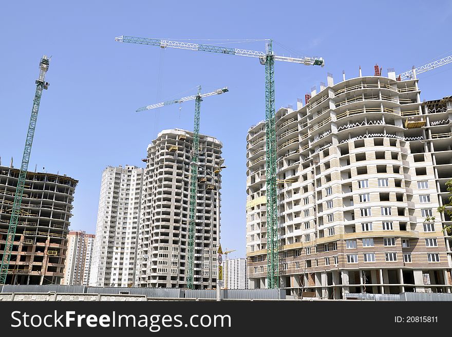 Construction of a residential community. Construction sites with cranes. Concrete structures. Construction of a residential community. Construction sites with cranes. Concrete structures.