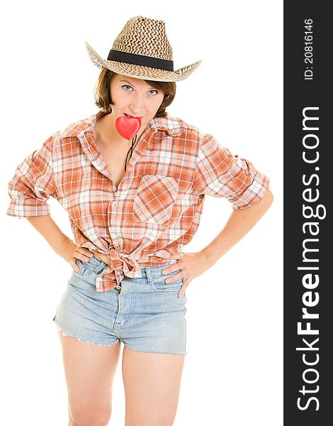 Cowboy woman holding a red heart in his teeth on a white background.