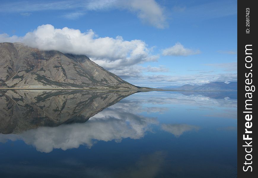 Perfect reflection on a peaceful lake near the Alaska Highway in the Yukon Territory. Perfect reflection on a peaceful lake near the Alaska Highway in the Yukon Territory