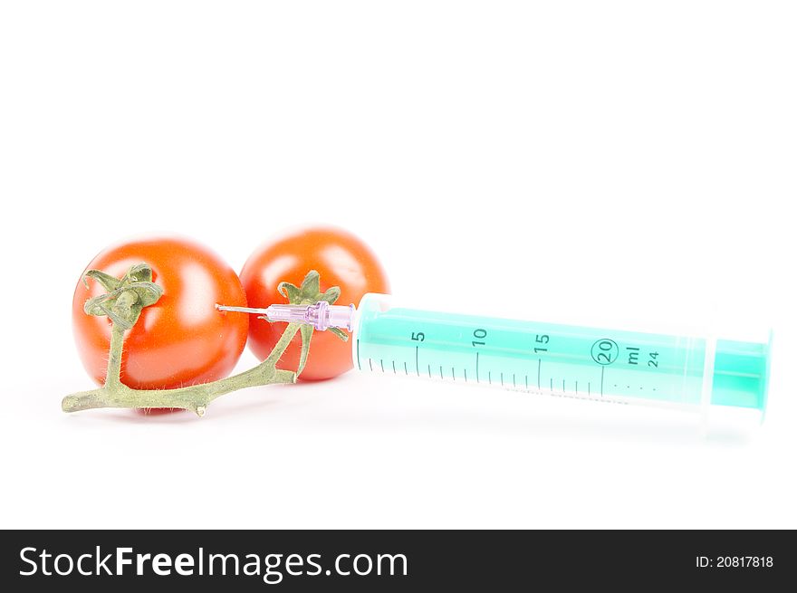 Tomatoes and syringe isolated of a white background. Tomatoes and syringe isolated of a white background