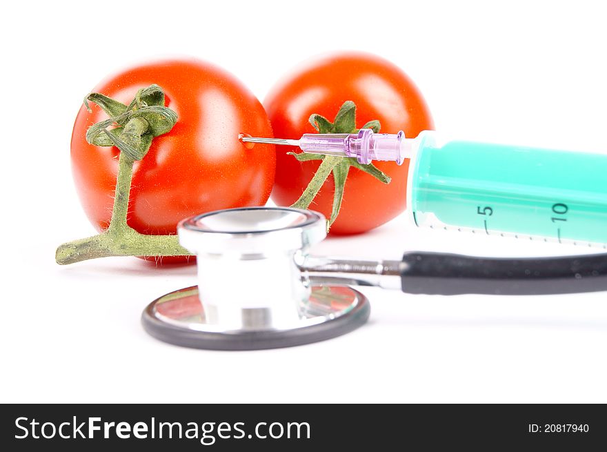 Tomatoes and syringe isolated of a white background. Tomatoes and syringe isolated of a white background
