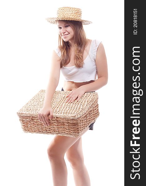 A girl in a straw hat with a straw suitcase, studio photography