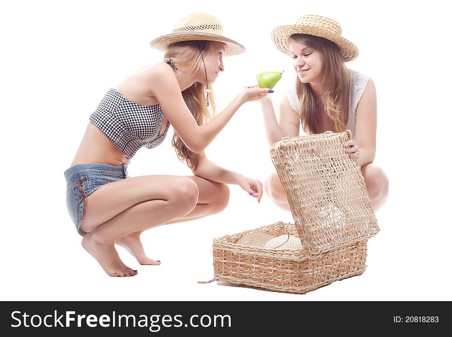 Two girls in straw hats with a straw suitcase, studio photography