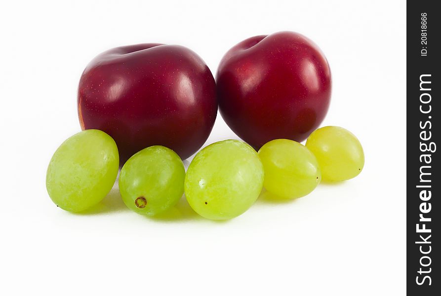 Plums and grapes on white background
