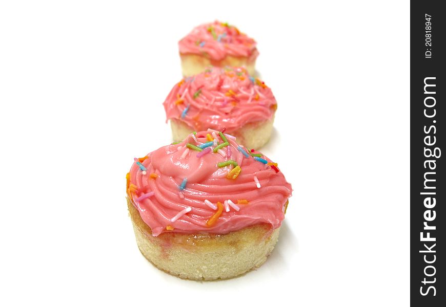 Set of three pink cupcakes with colorful sprinkles in a three different focal distances. Set of three pink cupcakes with colorful sprinkles in a three different focal distances.