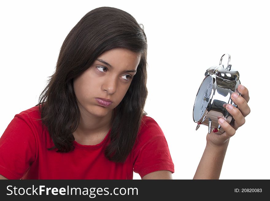 Teen girl angry at the alarm clock on white background. Teen girl angry at the alarm clock on white background