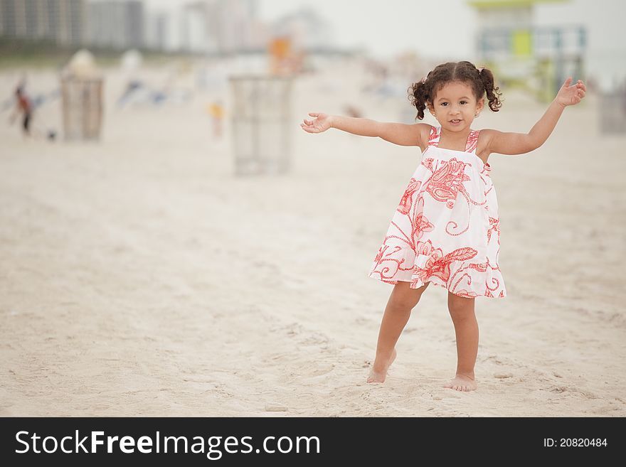 Image of a girl outstretching her arms on the beach