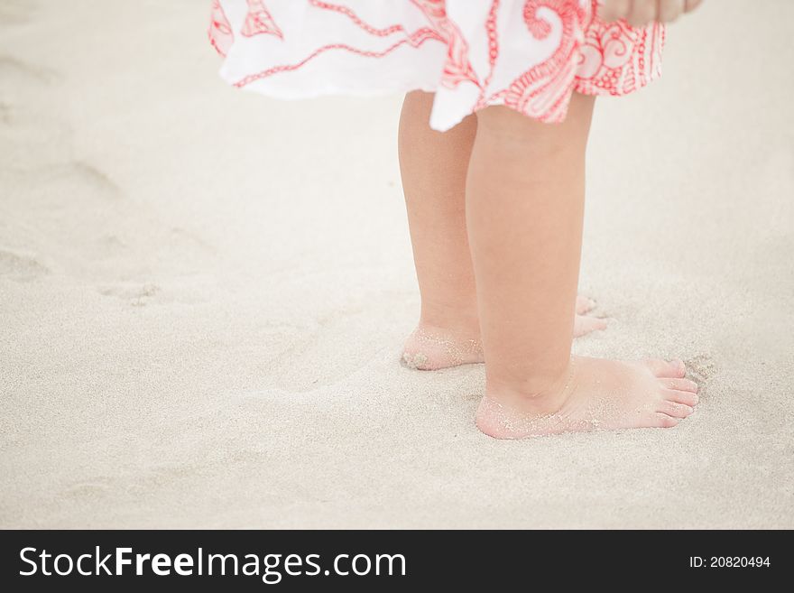 Child feet on the sand