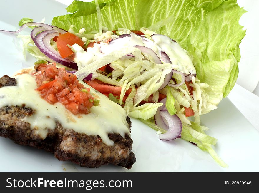 Cheeseburger with salsa and a salad ready for dinner. Cheeseburger with salsa and a salad ready for dinner.