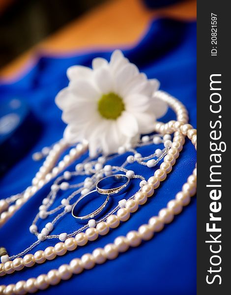 Wedding rings and flower on a blue dress