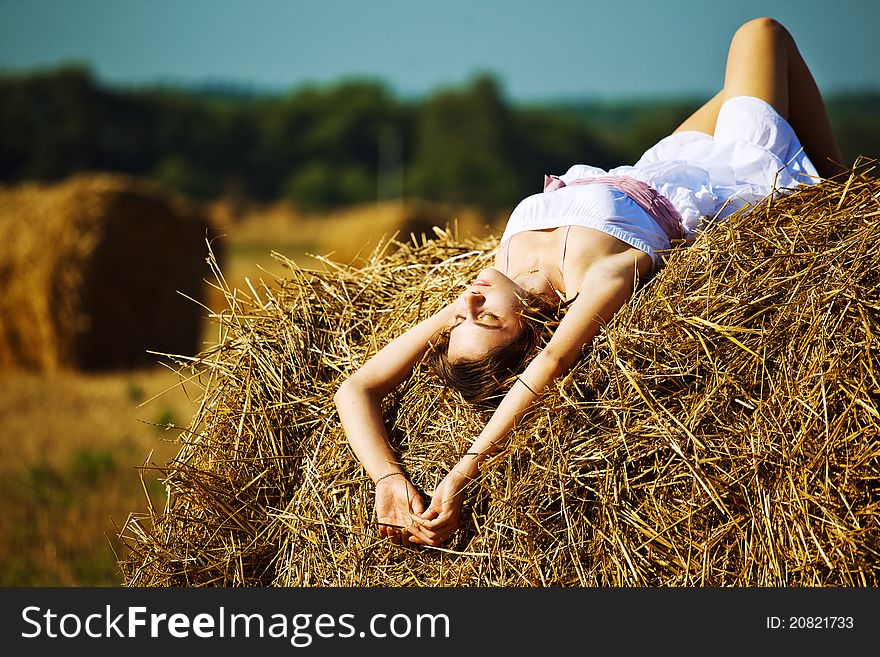 Beautiful girl enjoying the nature on fresh straw