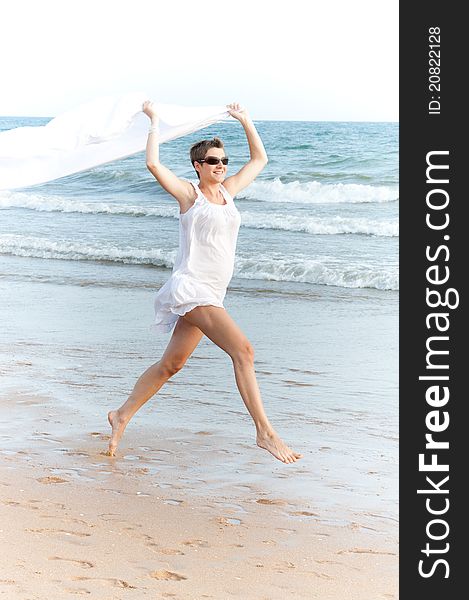 Woman Is Running On The Beach With White Shawl
